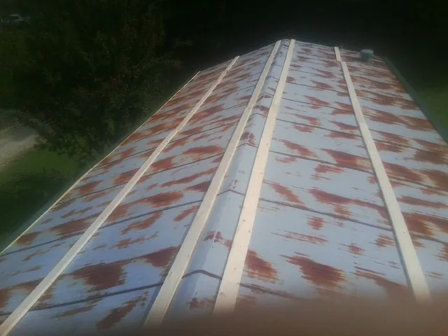 Rusted metal roof panels with new wood purlins before replacement — Storm Damage Roof Repair in Corfu by Roofing Brothers