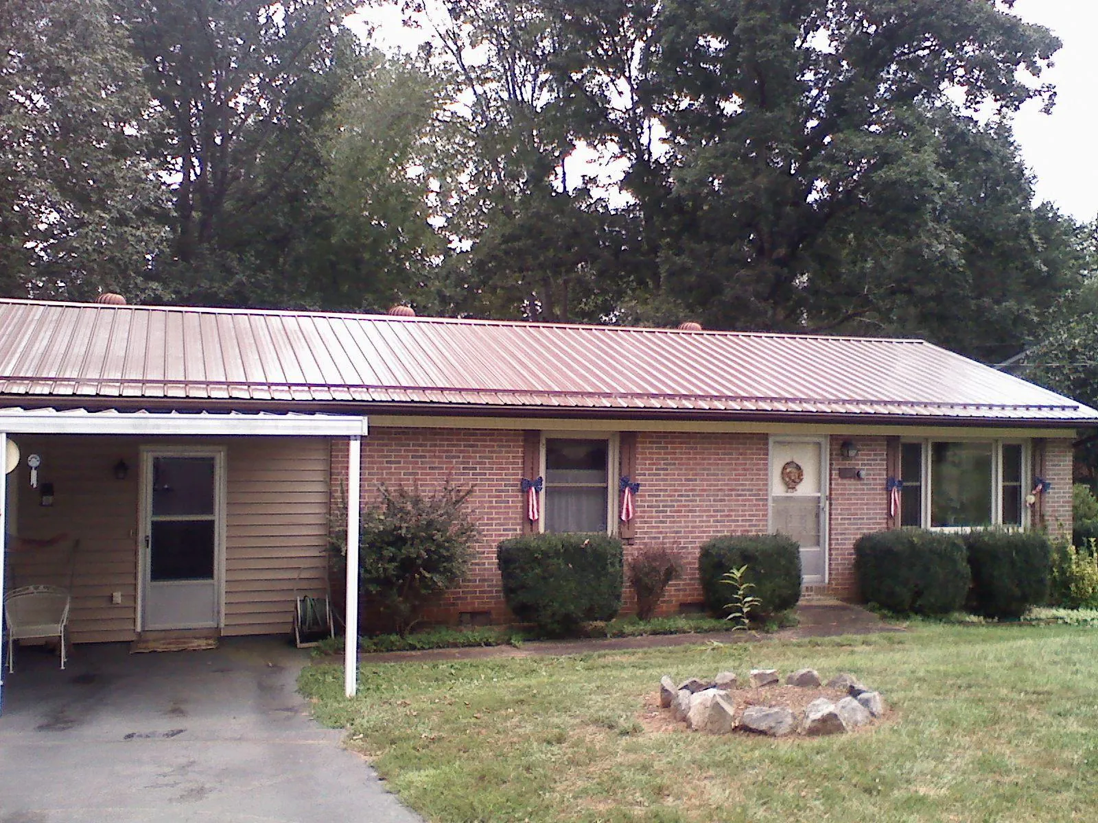 Bronze metal roof and carport on a brick ranch home — Roof Repair work by our crew in Corfu